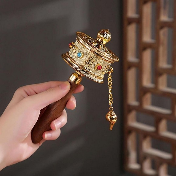 Bàn tay người hành hương quay bánh xe cầu nguyện Mani bằng đồng