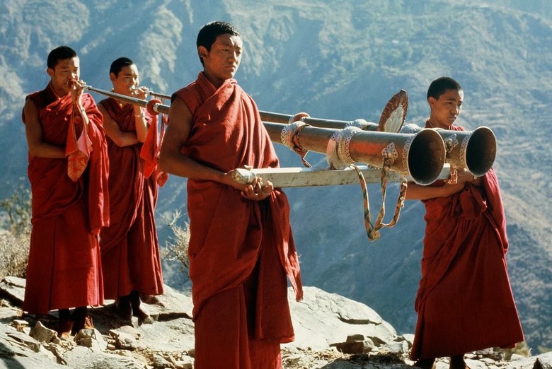 Các nhà sư thổi kèn dài dungchen trên mái một tu viện ở Tây Tạng