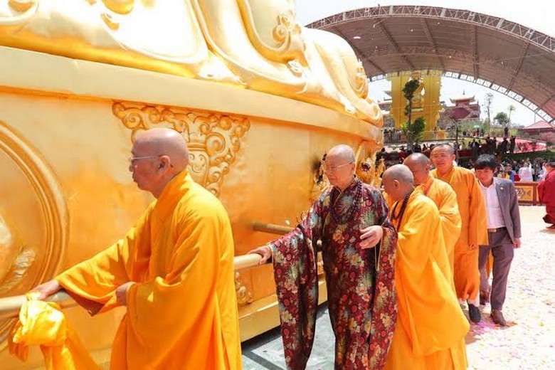 Người hành hương quay dãy bánh xe cầu nguyện bằng đồng